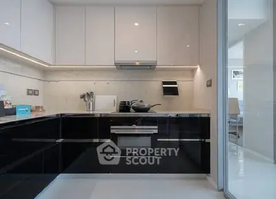 Modern kitchen with sleek black cabinets and built-in oven