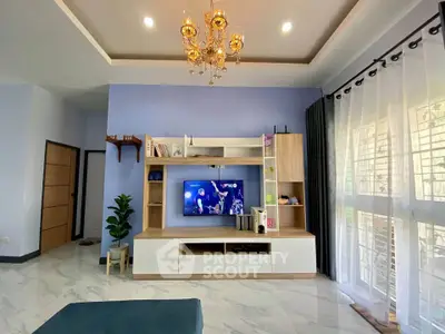 Elegant living room with modern entertainment center and chandelier lighting