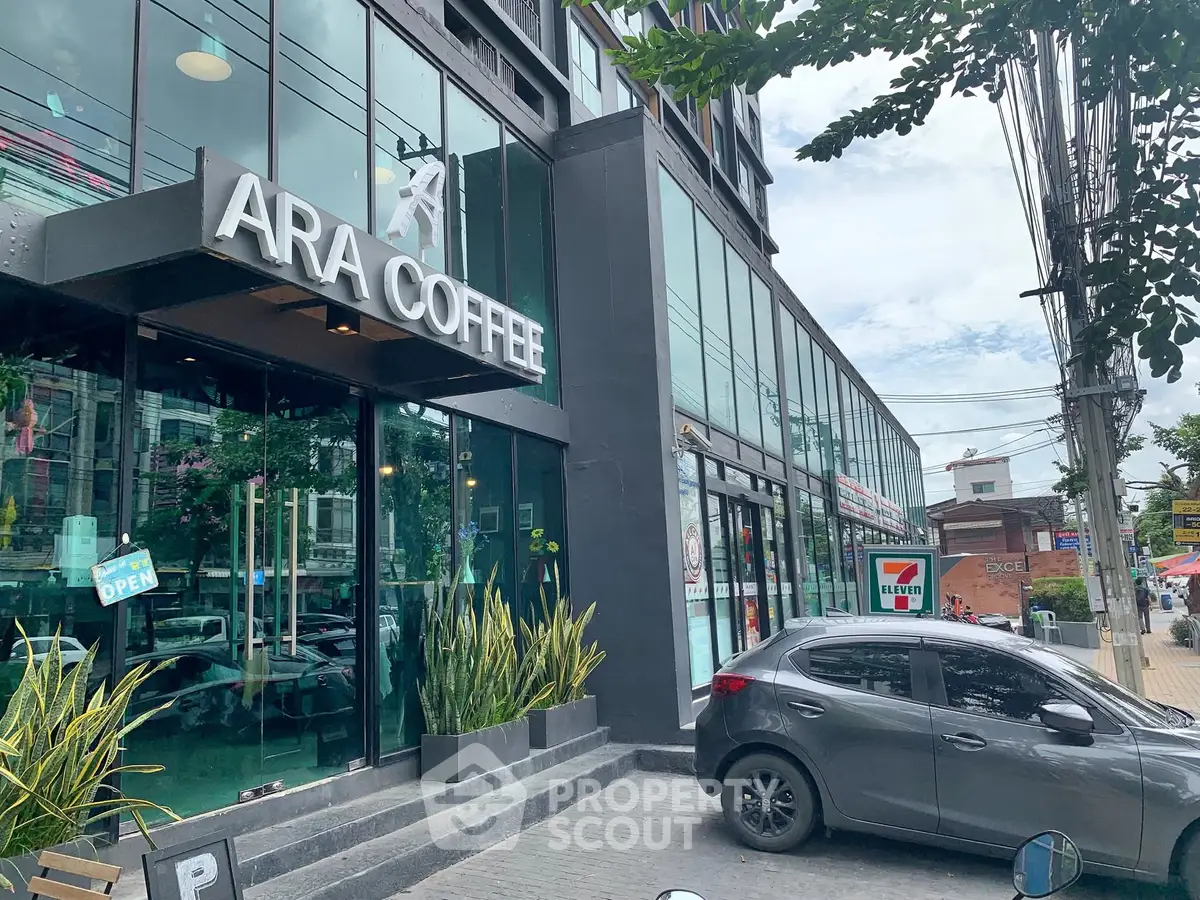 Modern commercial building with coffee shop and convenience store frontage.