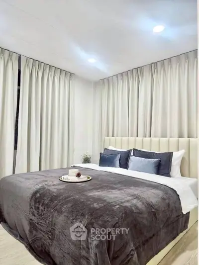 Luxurious bedroom with plush bedding and elegant curtains, perfect for relaxation.