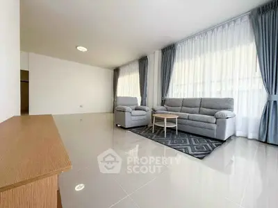 Spacious living room with modern gray sofa and large windows for natural light.