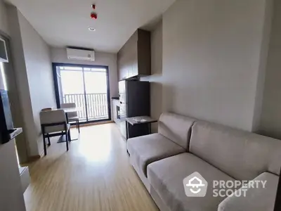 Modern living room with balcony view and sleek furniture in a cozy apartment.