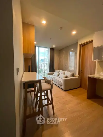 Modern living room with city view, featuring cozy sofa and stylish bar seating in a high-rise apartment.