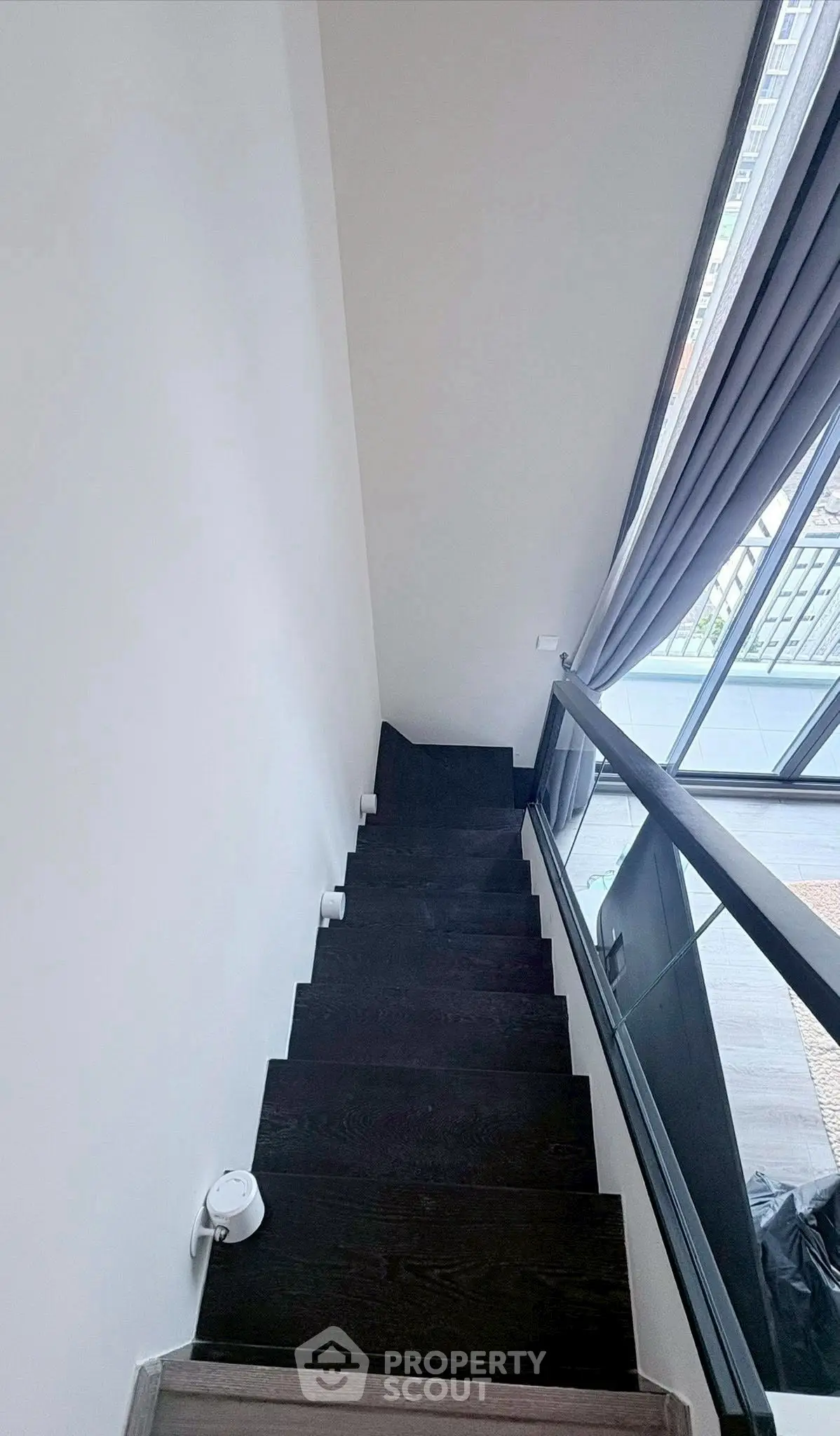 Modern staircase with sleek design and large window view