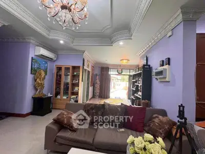 Luxurious living room with elegant chandelier and plush seating in a spacious open layout.