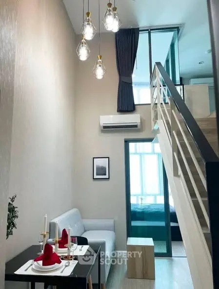 Modern loft apartment with stylish dining area and mezzanine bedroom, featuring high ceilings and elegant lighting.