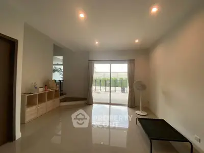 Spacious living room with large windows and balcony access, perfect for natural light and outdoor views.