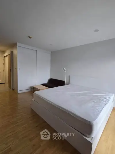 Spacious bedroom with minimalist design and wooden flooring