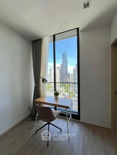 Modern study room with city view, featuring sleek desk and chair by large window.