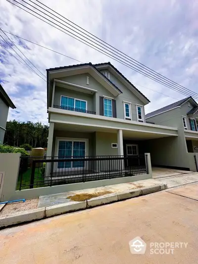 Modern two-story house with spacious driveway and lush surroundings