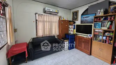 Cozy living room with sofa, TV, and ample storage in a compact space.
