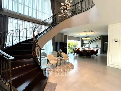 Luxurious open-plan living room with elegant staircase and modern dining area