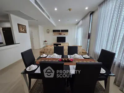 Elegant dining area with modern decor and natural light in a spacious living room.