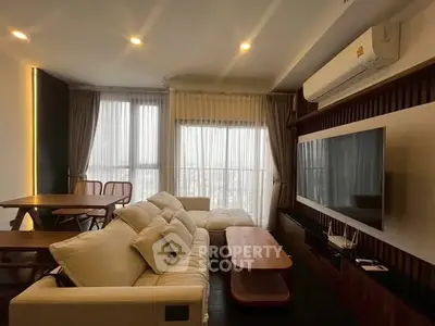 Modern living room with cozy sofa and large TV, featuring elegant curtains and ambient lighting.