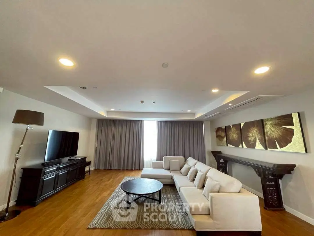 Spacious living room with modern decor and large sofa, perfect for relaxation and entertainment.