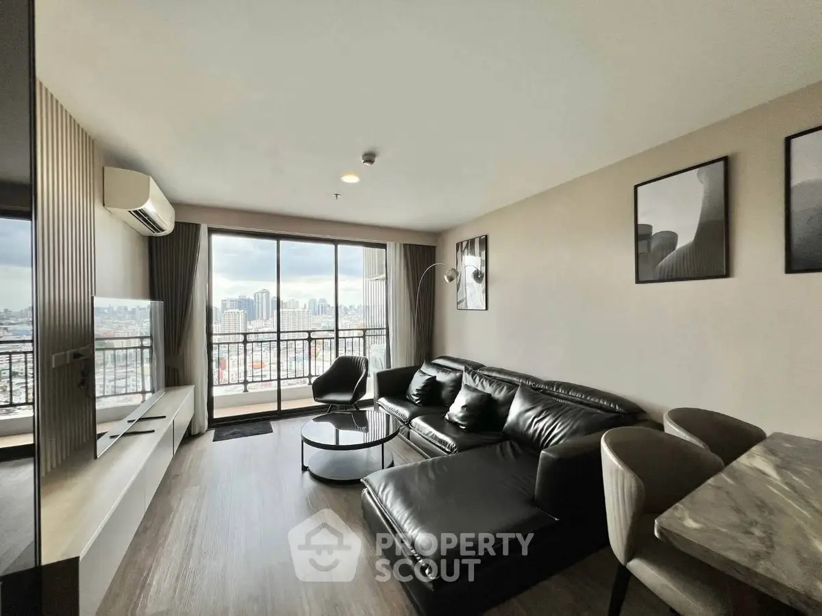 Modern living room with city view, sleek furniture, and large windows in a high-rise apartment.