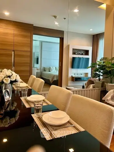 Luxurious dining area with elegant table setting and view into cozy living room and bedroom.