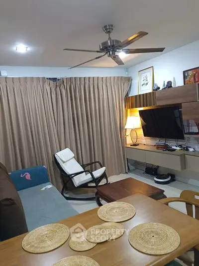 Cozy living room with modern furniture and ceiling fan, perfect for relaxation.
