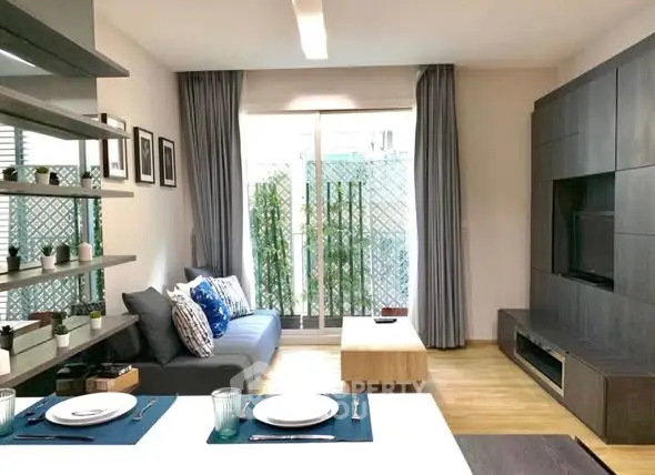 Modern living room with sleek furniture and large window, perfect for relaxation.