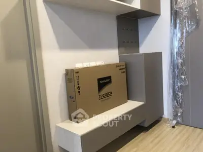 Modern interior with sleek shelving and new boxed TV, perfect for stylish living room setup.