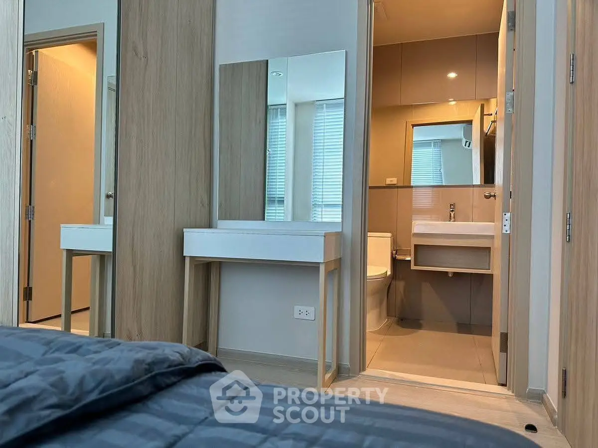 Modern bedroom with ensuite bathroom featuring sleek design and neutral tones.