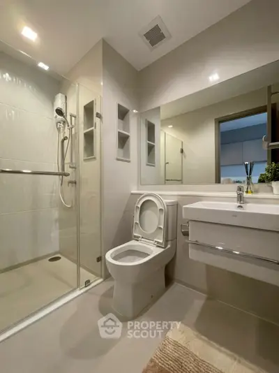 Modern bathroom with glass shower and sleek fixtures in a contemporary apartment.