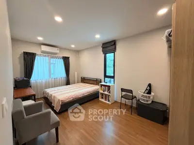 Spacious bedroom with modern decor and natural light, featuring a cozy bed and stylish furnishings.