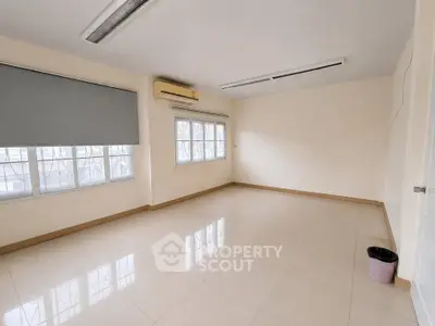 Spacious empty room with large windows and air conditioning, perfect for customization.