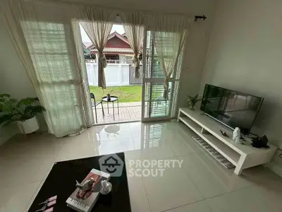 Bright living room with garden view, modern decor, and large windows for natural light.