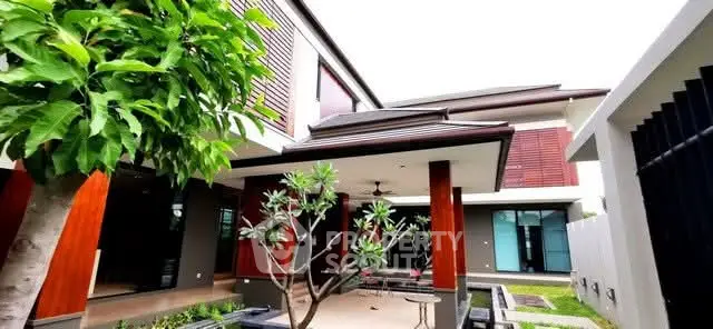 Modern luxury home exterior with lush garden and contemporary design.