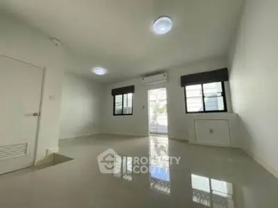 Spacious empty room with glossy floors and large windows, perfect for customization.