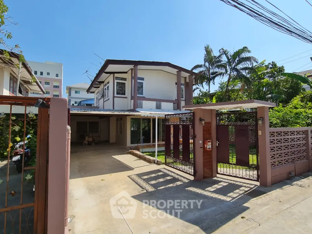 Charming two-story house with spacious driveway and lush garden in a serene neighborhood.