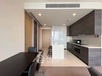 Modern kitchen with sleek cabinetry and dining area in open layout apartment.