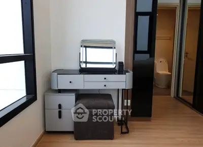 Modern bedroom with stylish vanity and ensuite bathroom in a contemporary apartment.