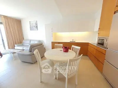 Modern open-plan kitchen and living area with sleek furniture and natural light.