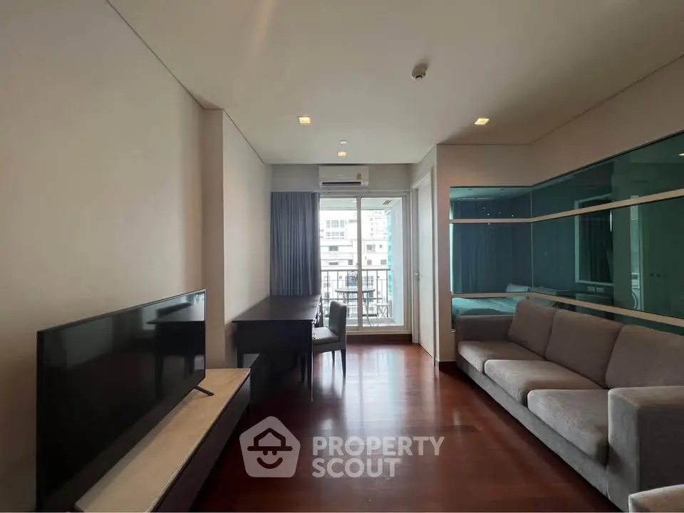 Modern living room with sleek furniture and large window offering city view