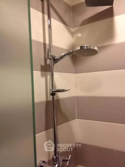 Modern bathroom shower with sleek chrome fixtures and stylish tile design.