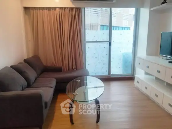 Cozy living room with modern sofa and glass coffee table, perfect for relaxation.