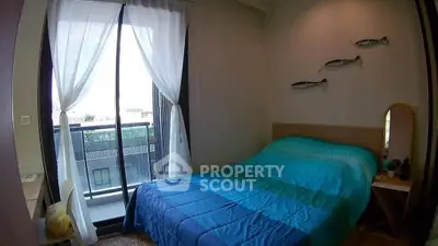 Cozy bedroom with balcony access and stylish decor in modern apartment.