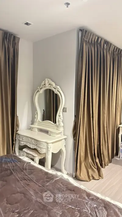 Elegant bedroom with luxurious drapes and ornate vanity mirror