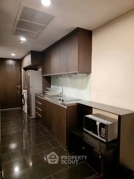 Modern kitchen with sleek dark cabinetry and stainless steel appliances