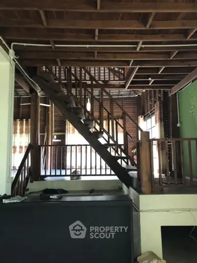 Charming wooden interior with rustic staircase and open layout, perfect for cozy living.