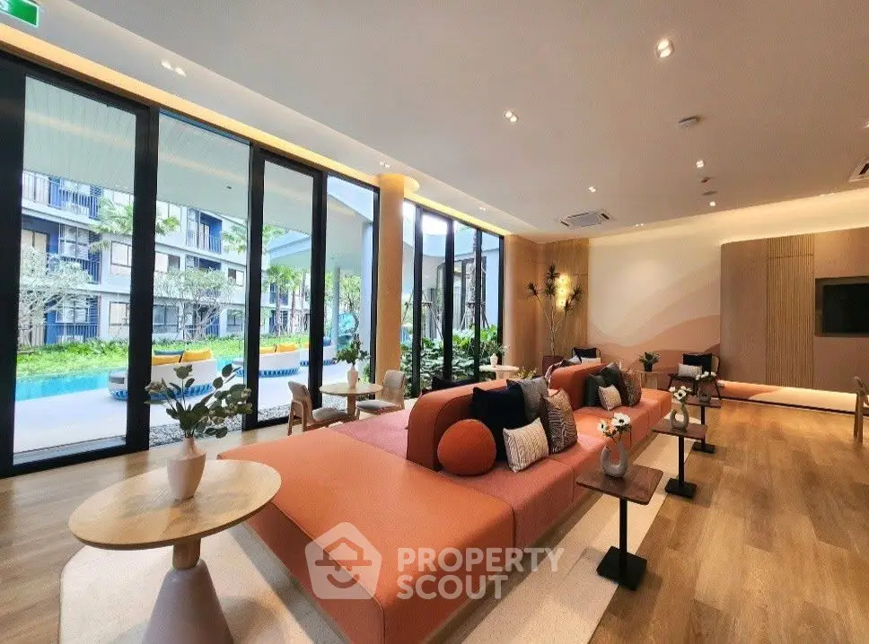 Luxurious modern living room with pool view, featuring elegant furniture and large windows.