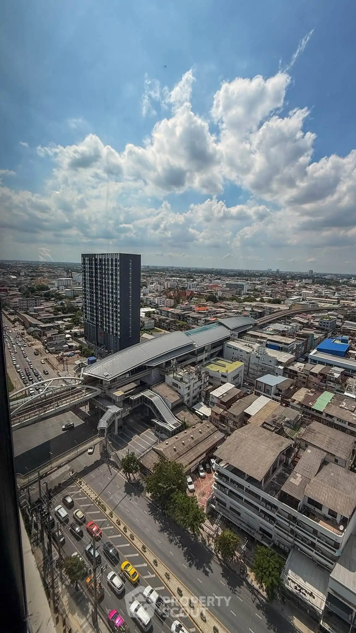 Stunning cityscape view from high-rise building with clear skies and bustling streets below.