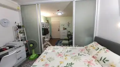Cozy bedroom with floral bedding and sliding glass doors leading to a living area.