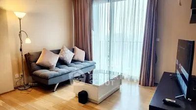 Modern living room with cozy sofa, floor lamp, and large window with curtains.