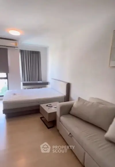 Modern studio apartment with cozy sofa and bed, perfect for urban living.