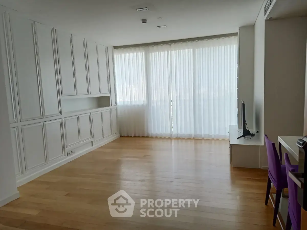 Spacious living room with elegant built-in cabinets and large windows for natural light.
