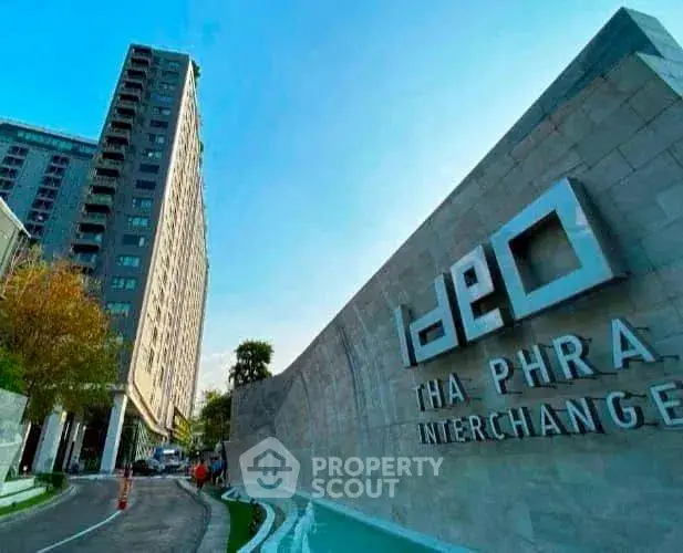 Modern high-rise building with Ideo Tha Phra Interchange signage, showcasing urban living.