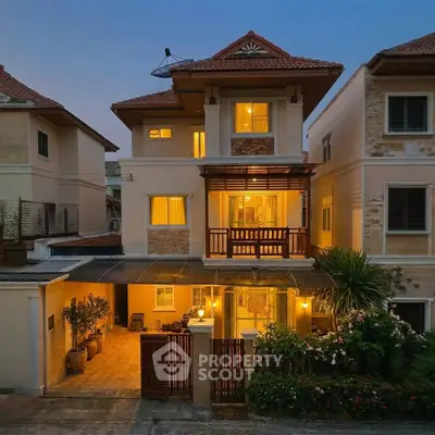 Charming three-story house with warm lighting and lush garden, perfect for family living in a serene neighborhood.